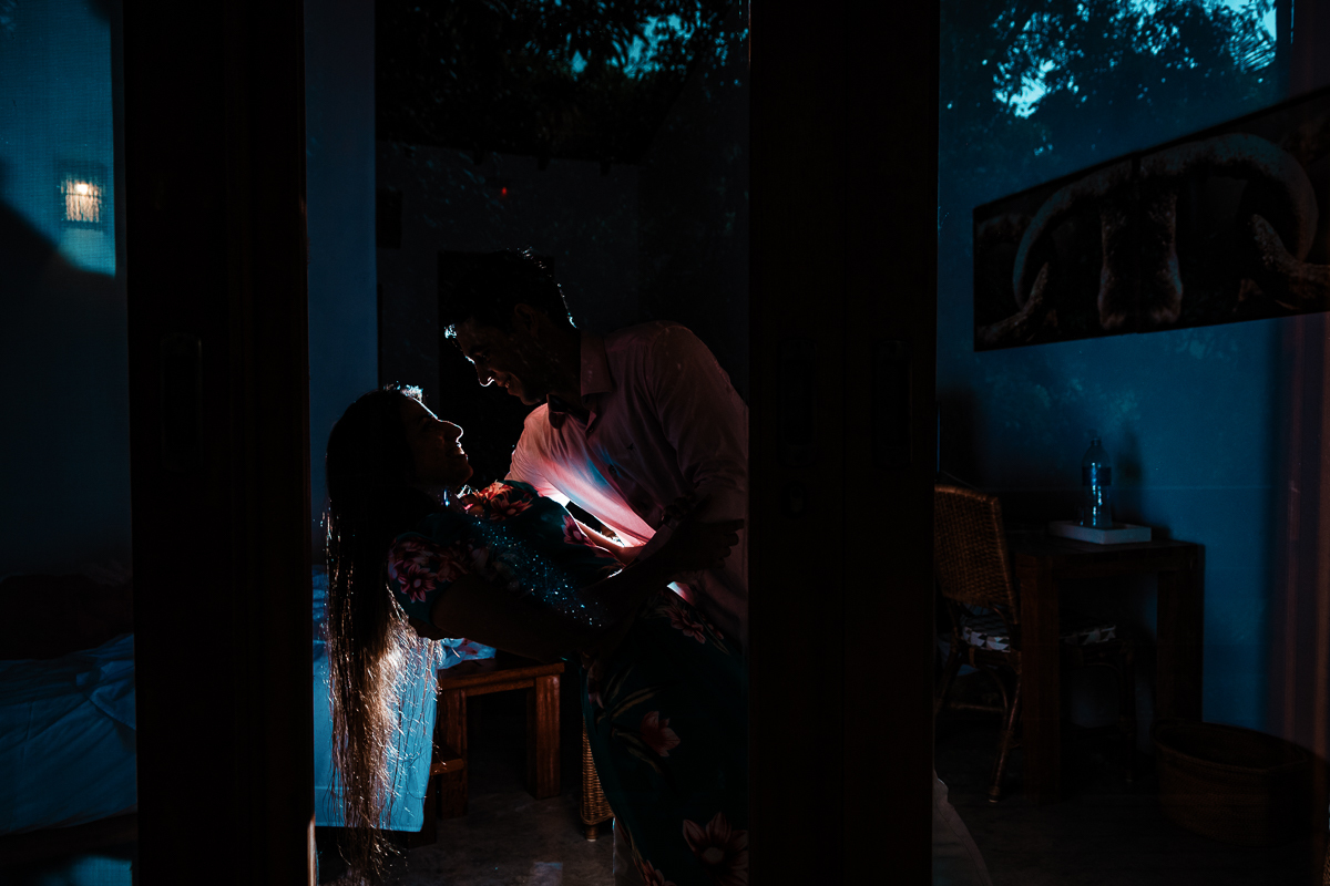fábio segura vanúvia em seus braços, os dois sorriem equanto são fotografados em um ensaio em ilhabela