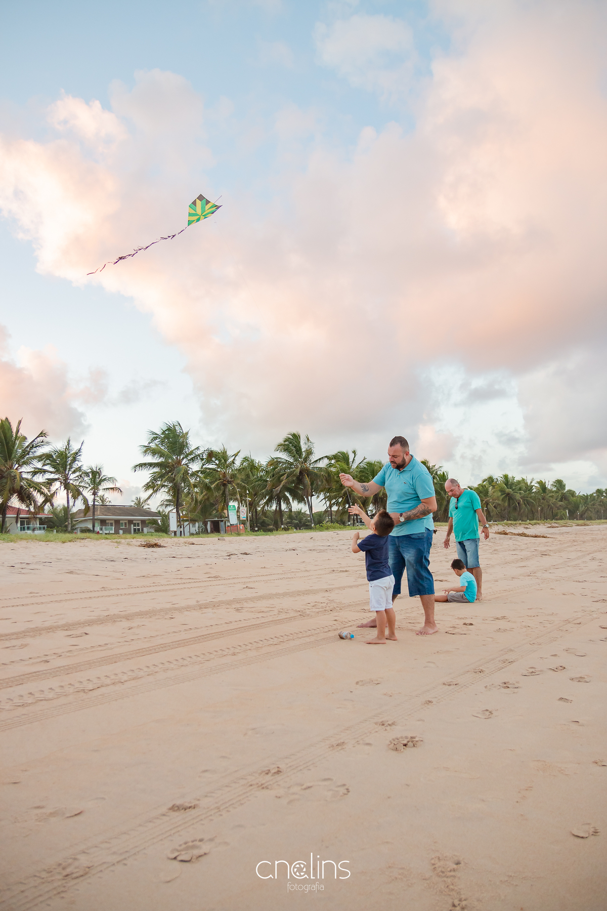 Pai, avô e netos brincando de pipa na beira mar do Paiva