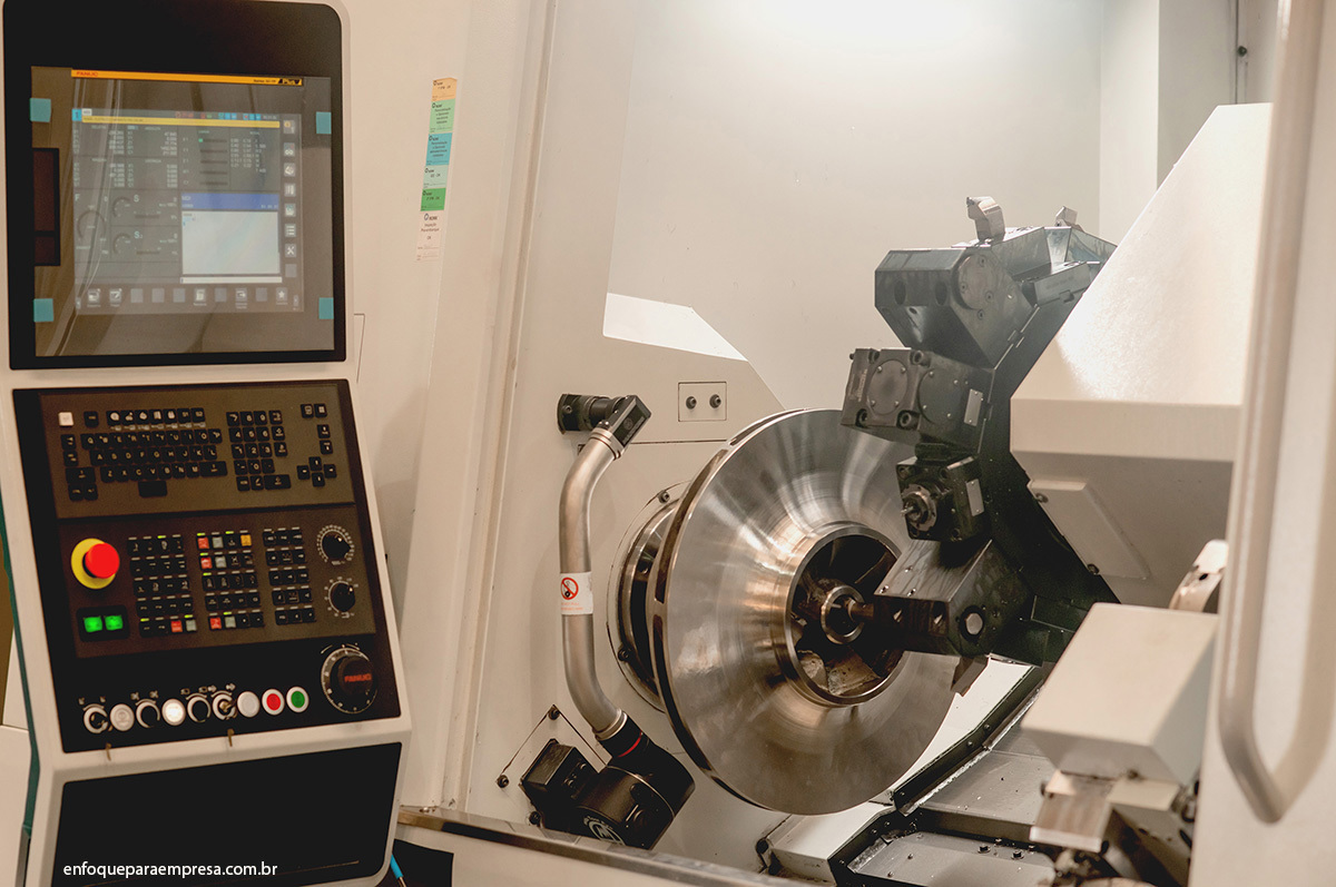 Fotografia de outro ângulo do equipamento e peça industrial sendo finalizada