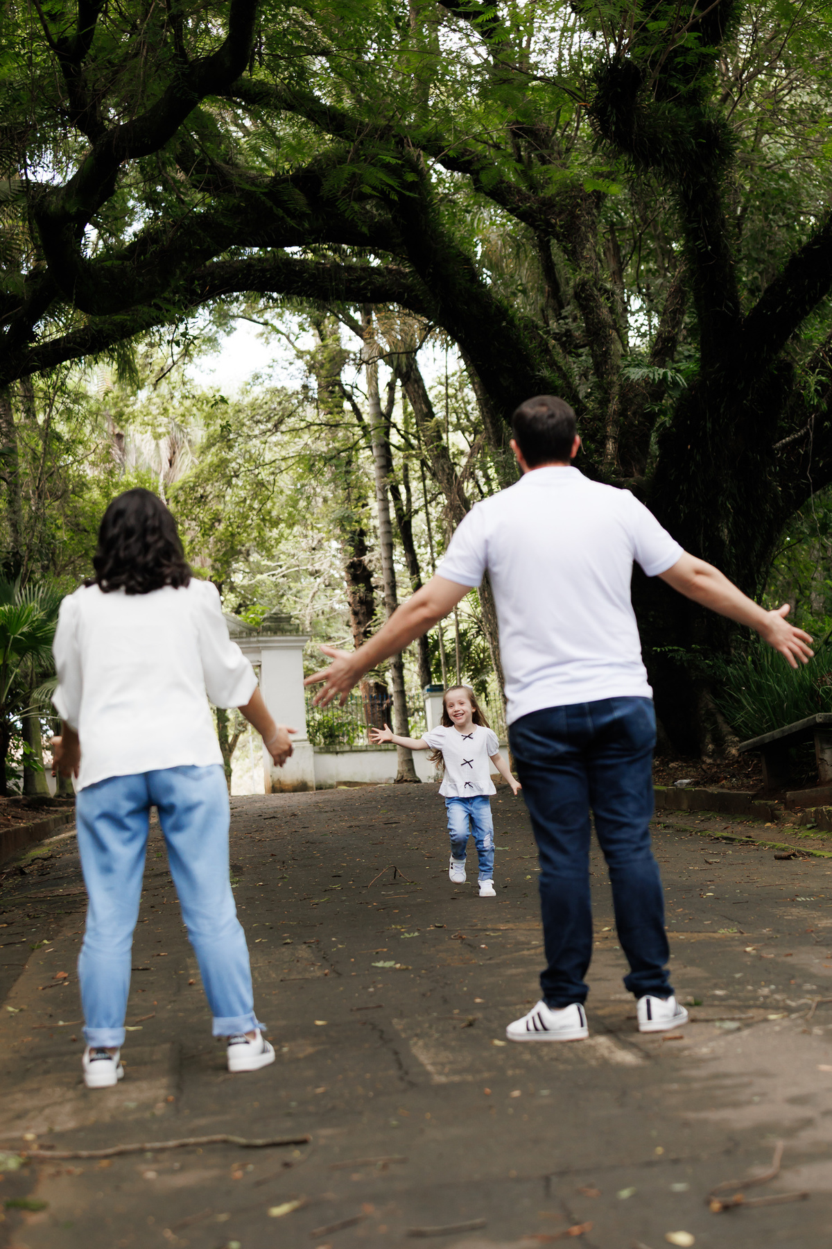 Família caminhando no parque durante ensaio gestante ao ar livre em Campinas.