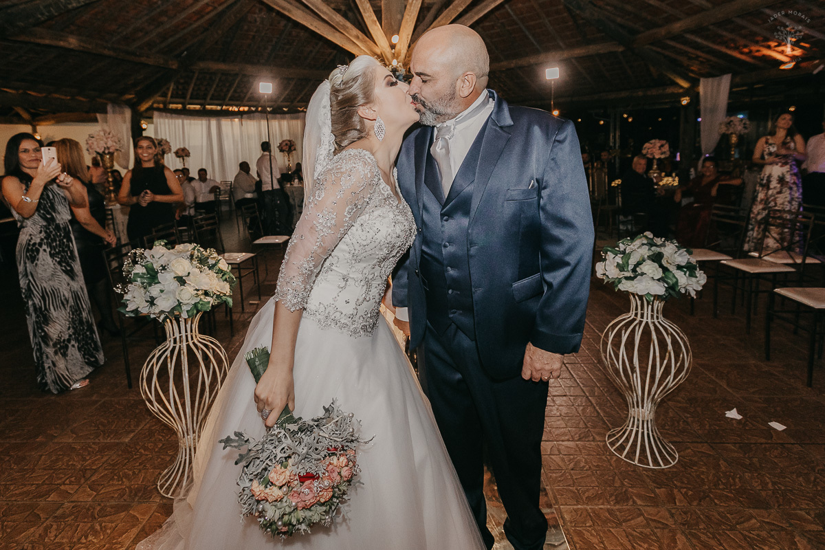 noivos apaixonados saem da cerimônia felizes