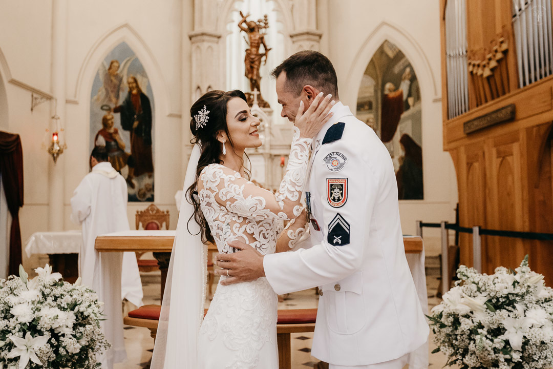 noiva faz carinho no noivo no altar