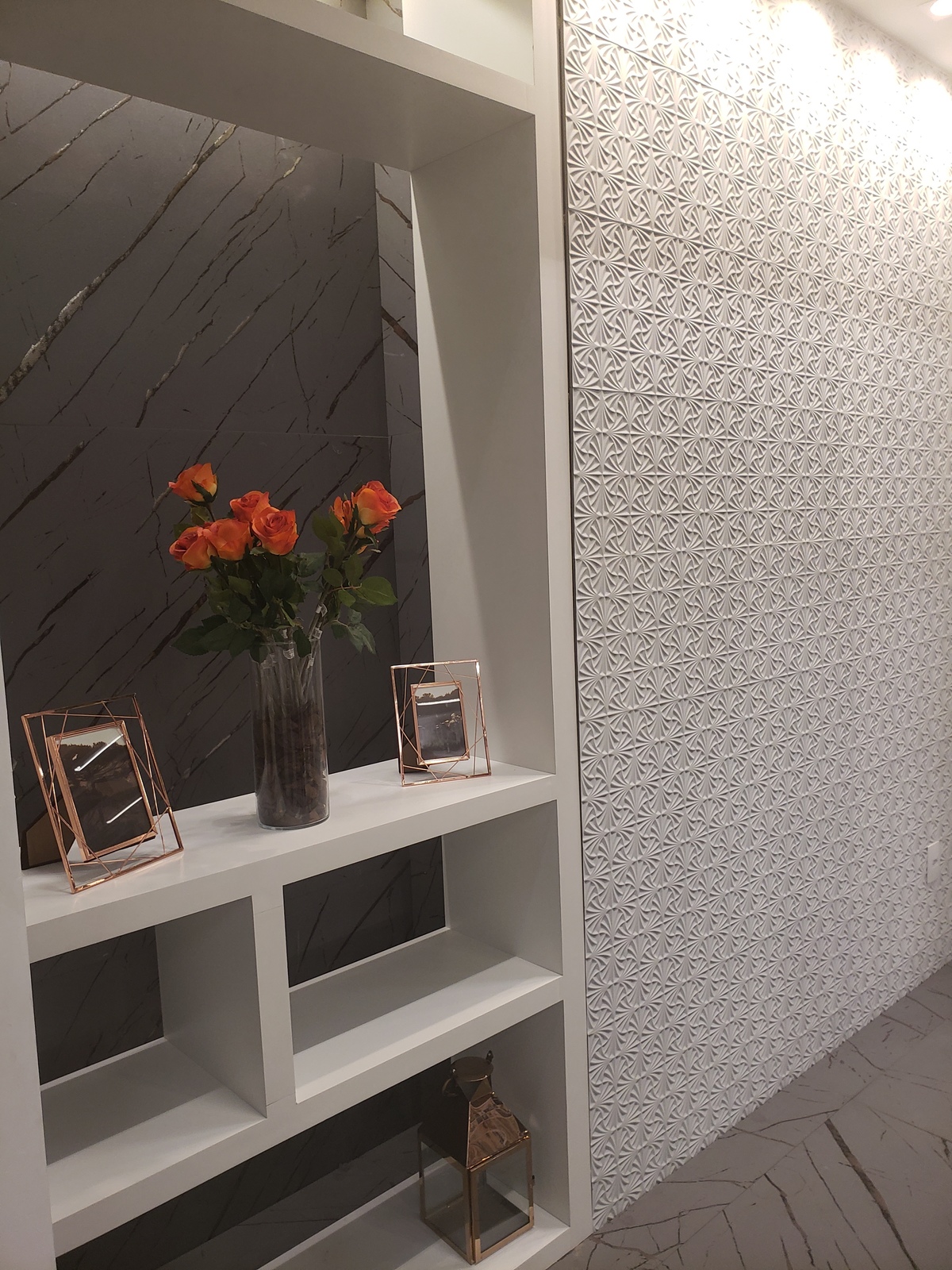 Painel em marcenaria jogando fundo em revestimento com painel lateral em porcelanato 3D e piso porcelanato.