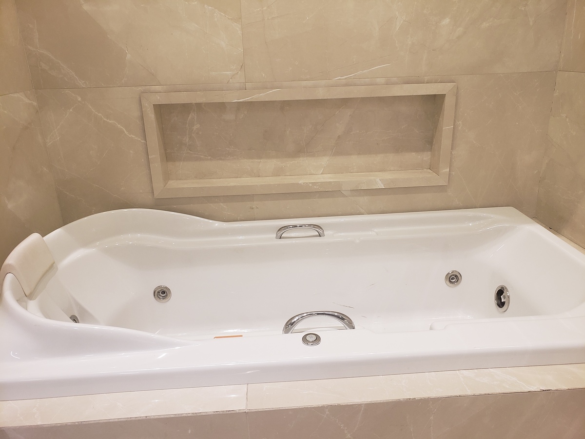 Banheira de hidromassagem atendida por um nicho adequado em tamanho e praticidade. 
