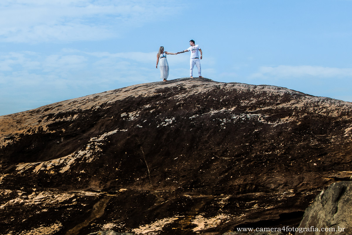 noivos em cima das pedras na praia