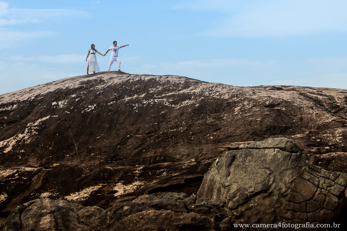 noivos em cima das pedras na praia