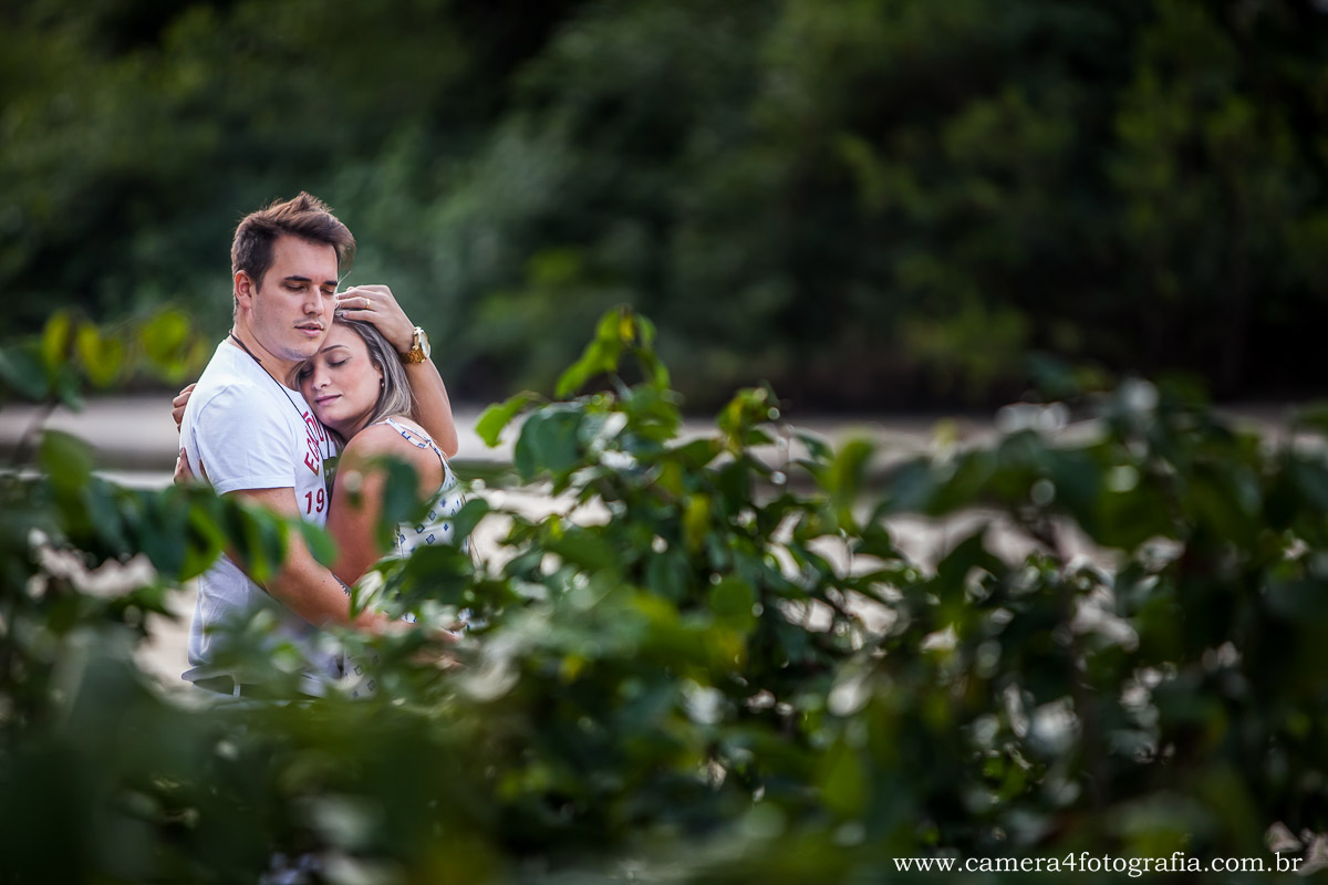 noiva e noivo se abraçando durante o ensaio na praia