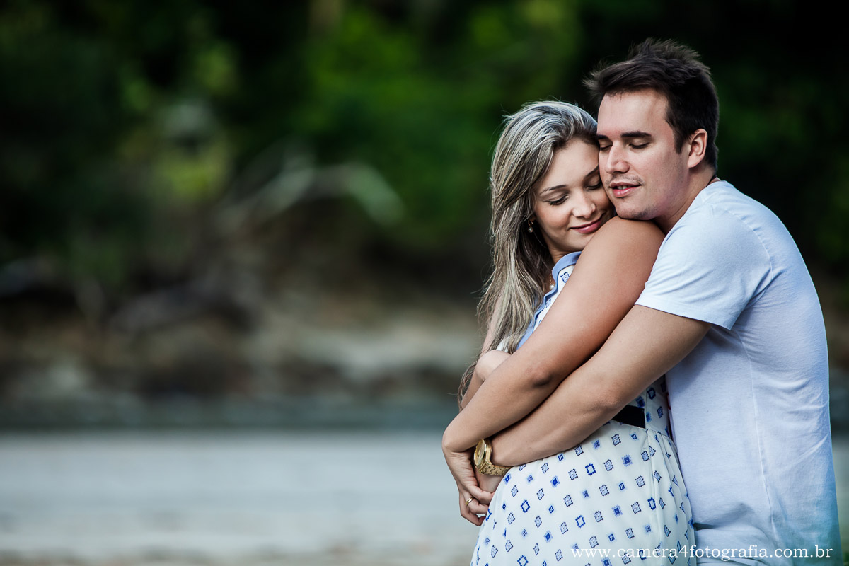 noiva e noivo se abraçando durante o ensaio na praia