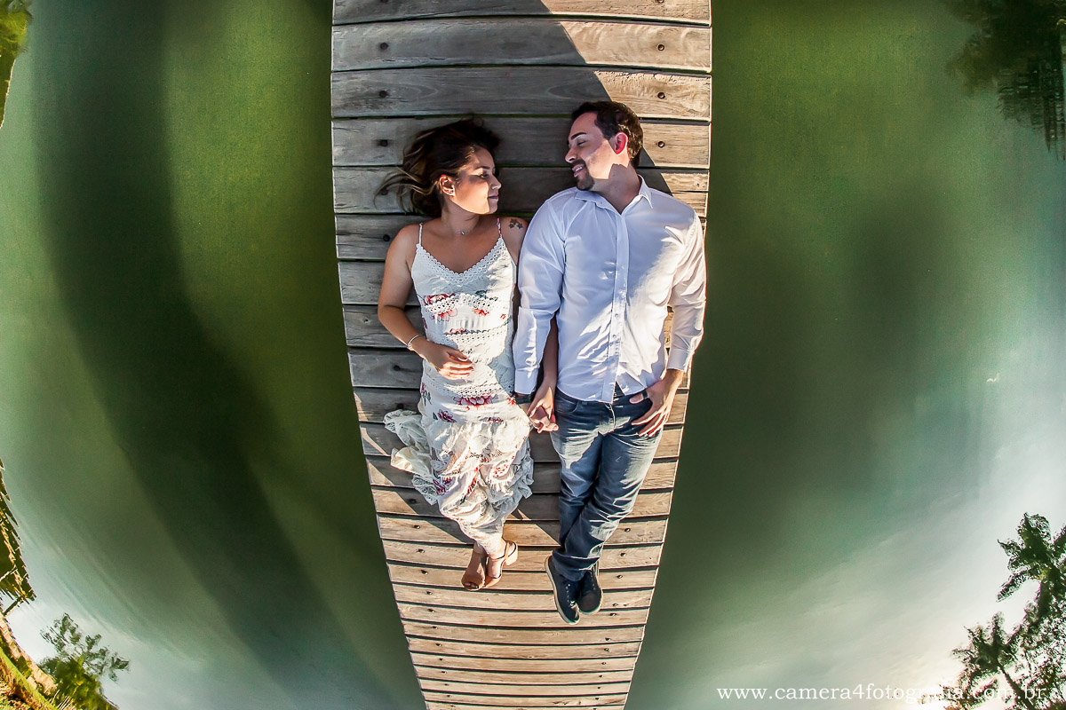 noivos deitas na ponte em cima do lago