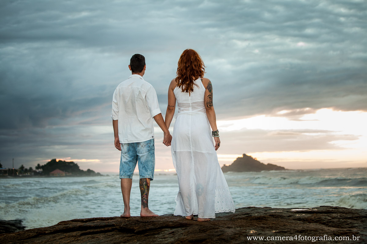 noivos na pedra na praia durante o ensaio pré wedding