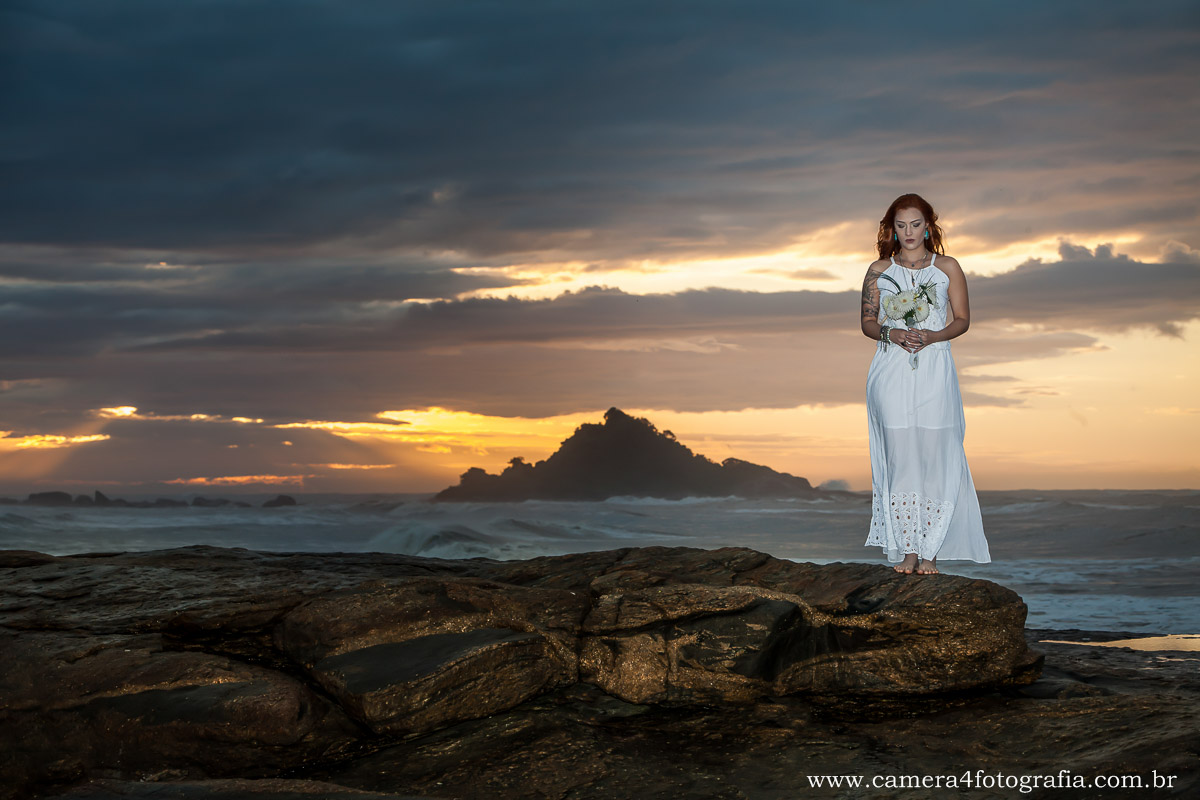 foto da noiva com o buquê na praia