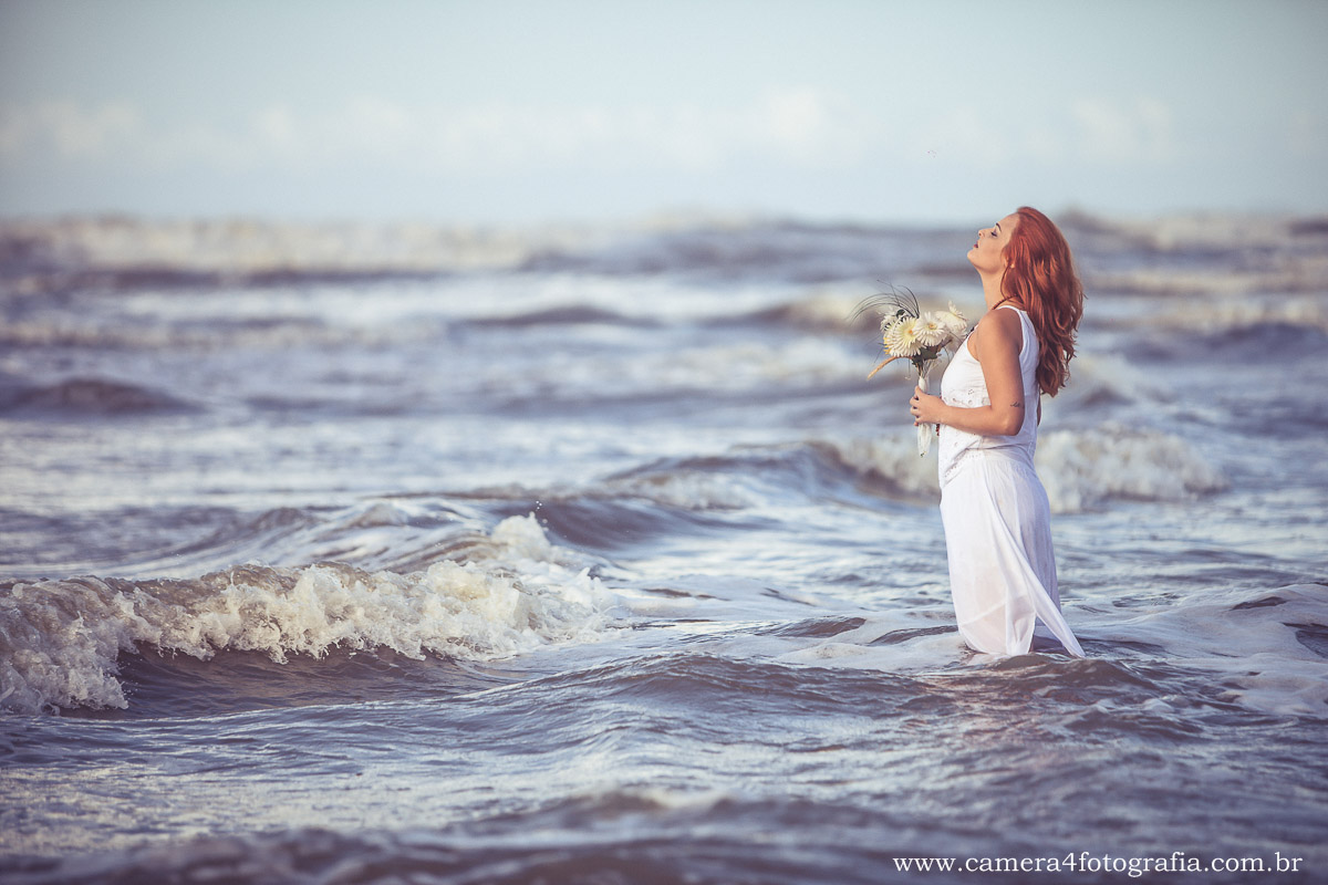 noiva com o buquê na praia