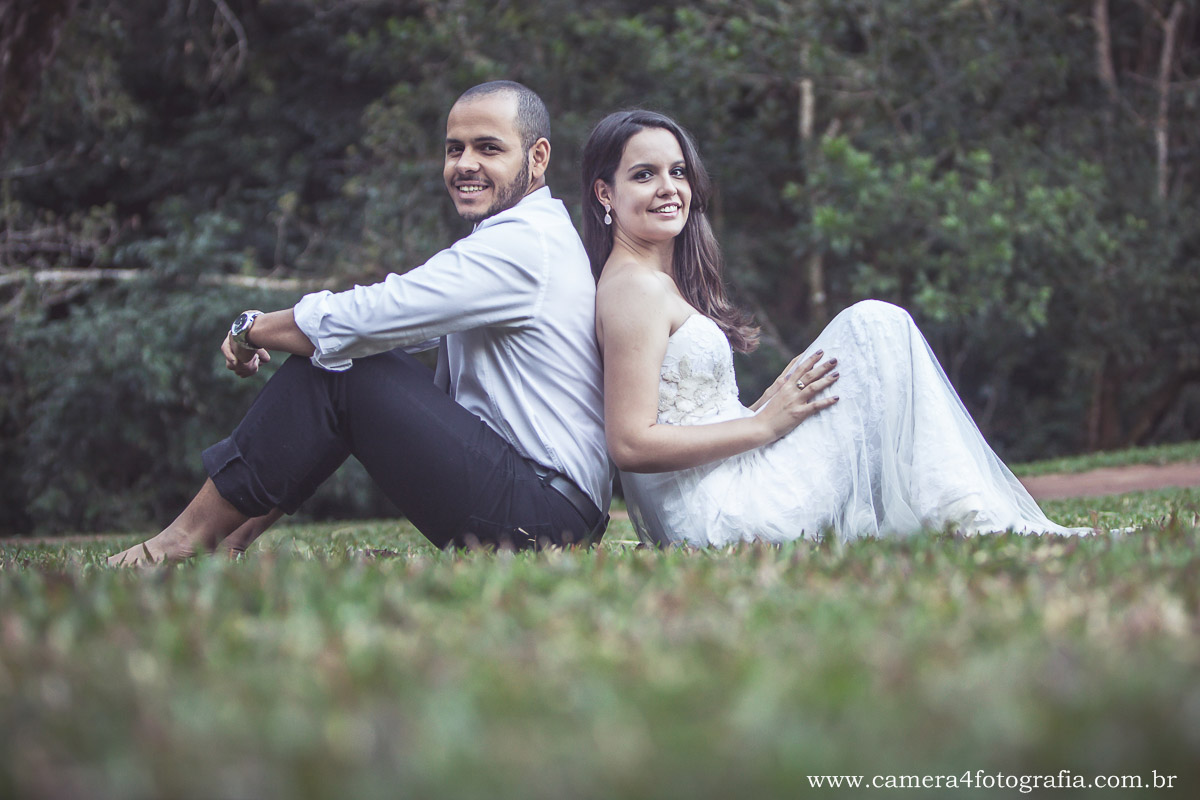 noivos sentados na grama durante o ensaio pré wedding