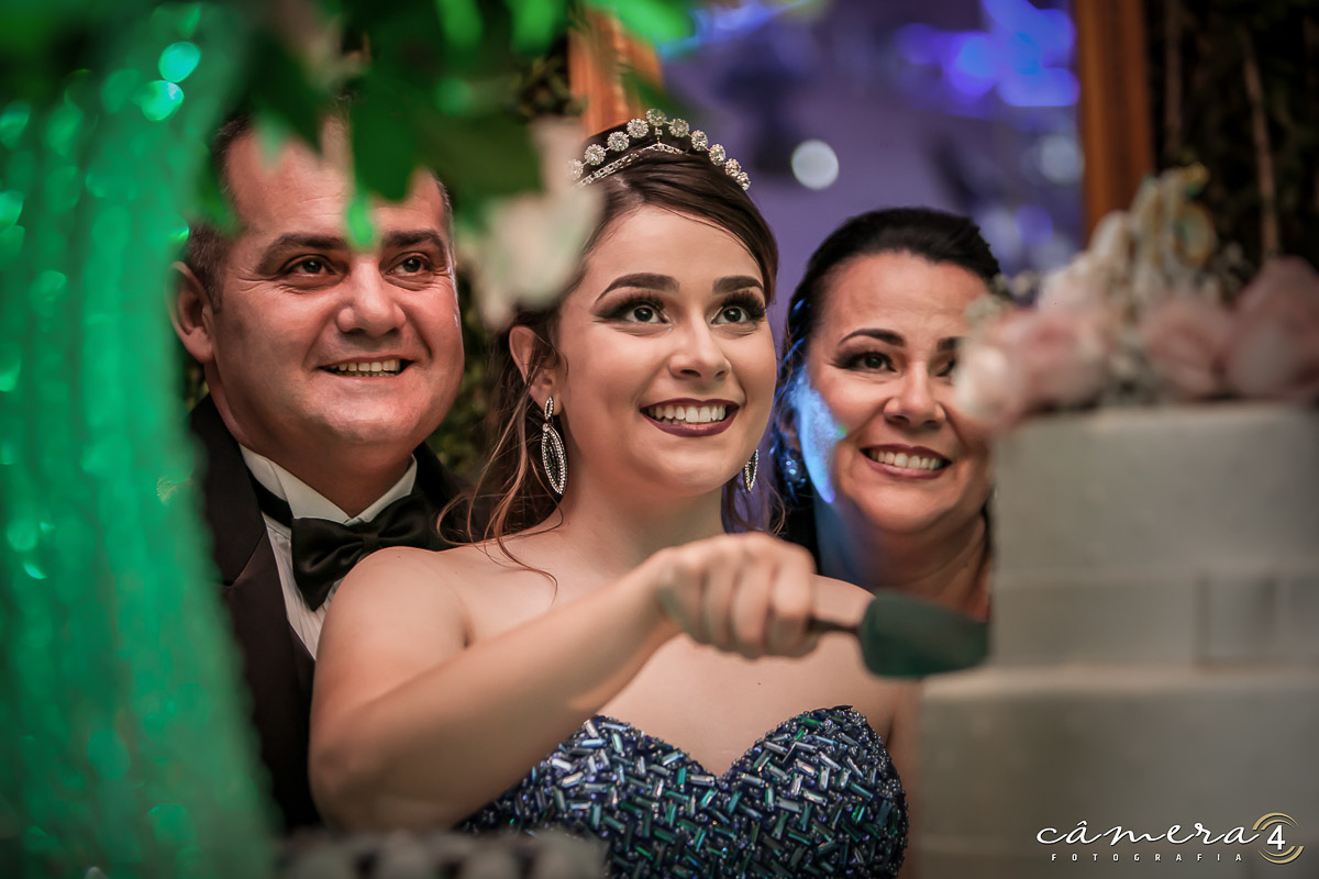 aniversariante cortando o bolo durante sua festa de 15 anos