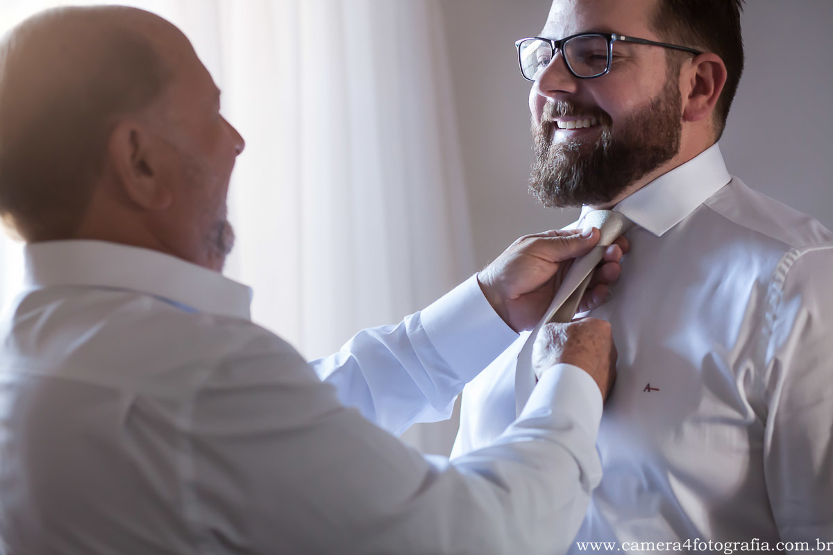 pai do noivo acertando a gravata do noivo antes do casamento