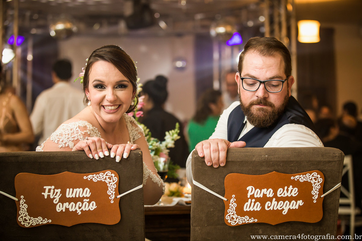 noivos sentados na mesa dos noivos durante o jantar do casamento