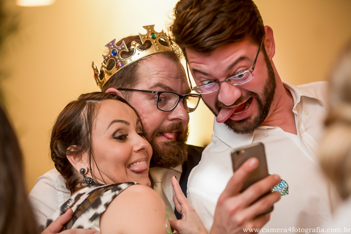 noivos fazendo careta com amigos durante a festa do casamento
