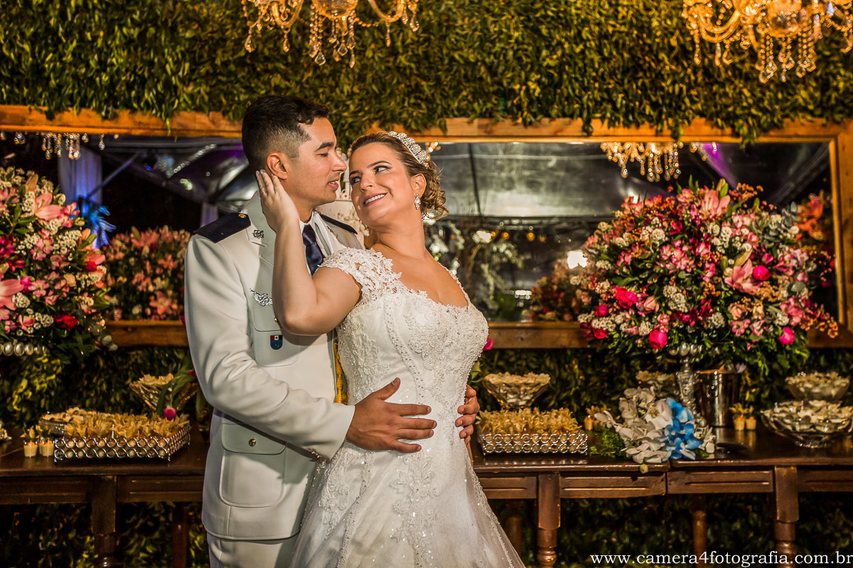 noivos na frente da mesa do bolo do casamento