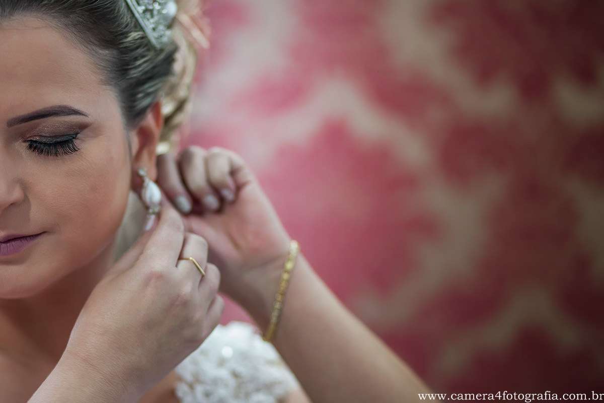 noiva colocando o brinco do casamento