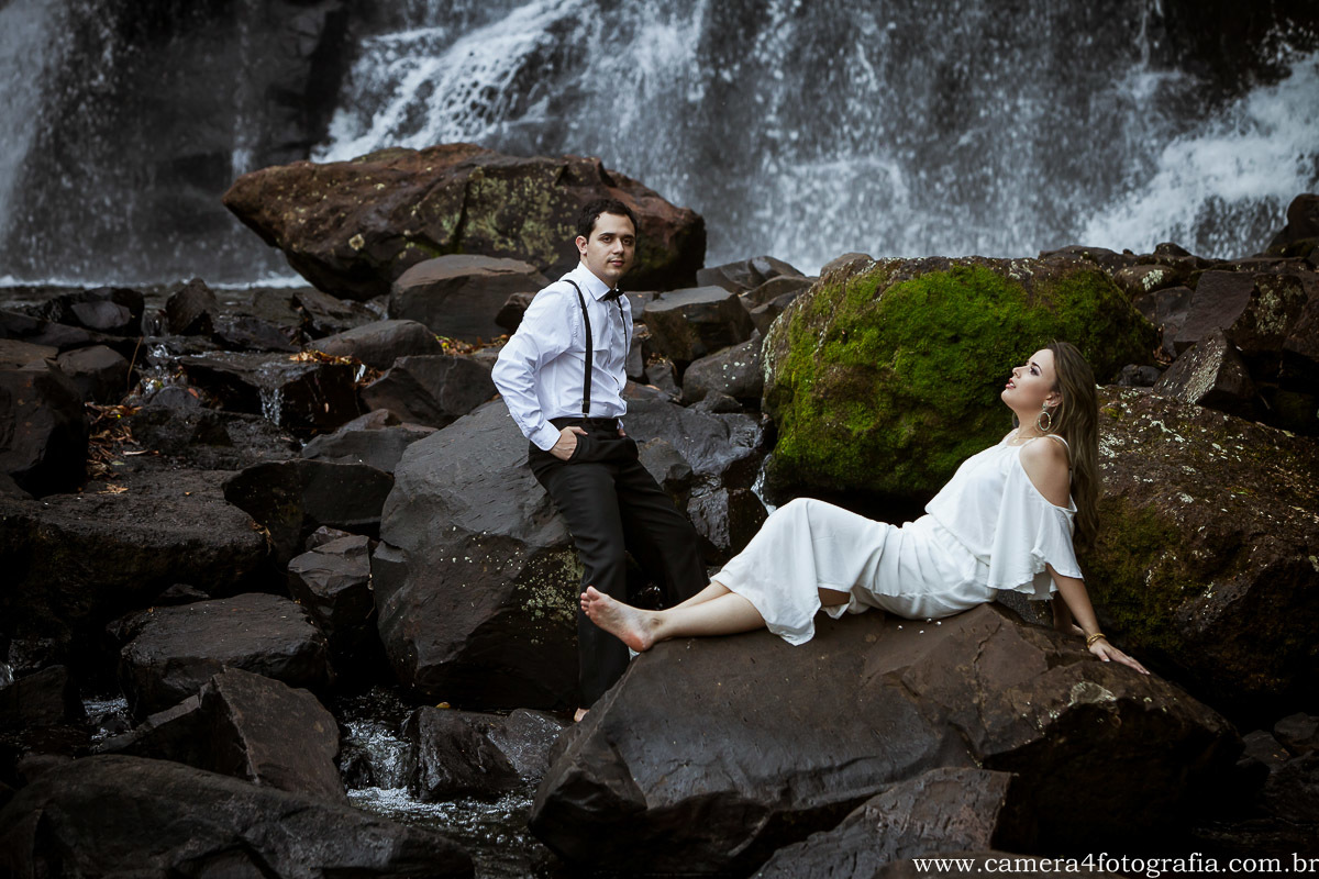 noivos deitados na pedra no ensaio pré casamento