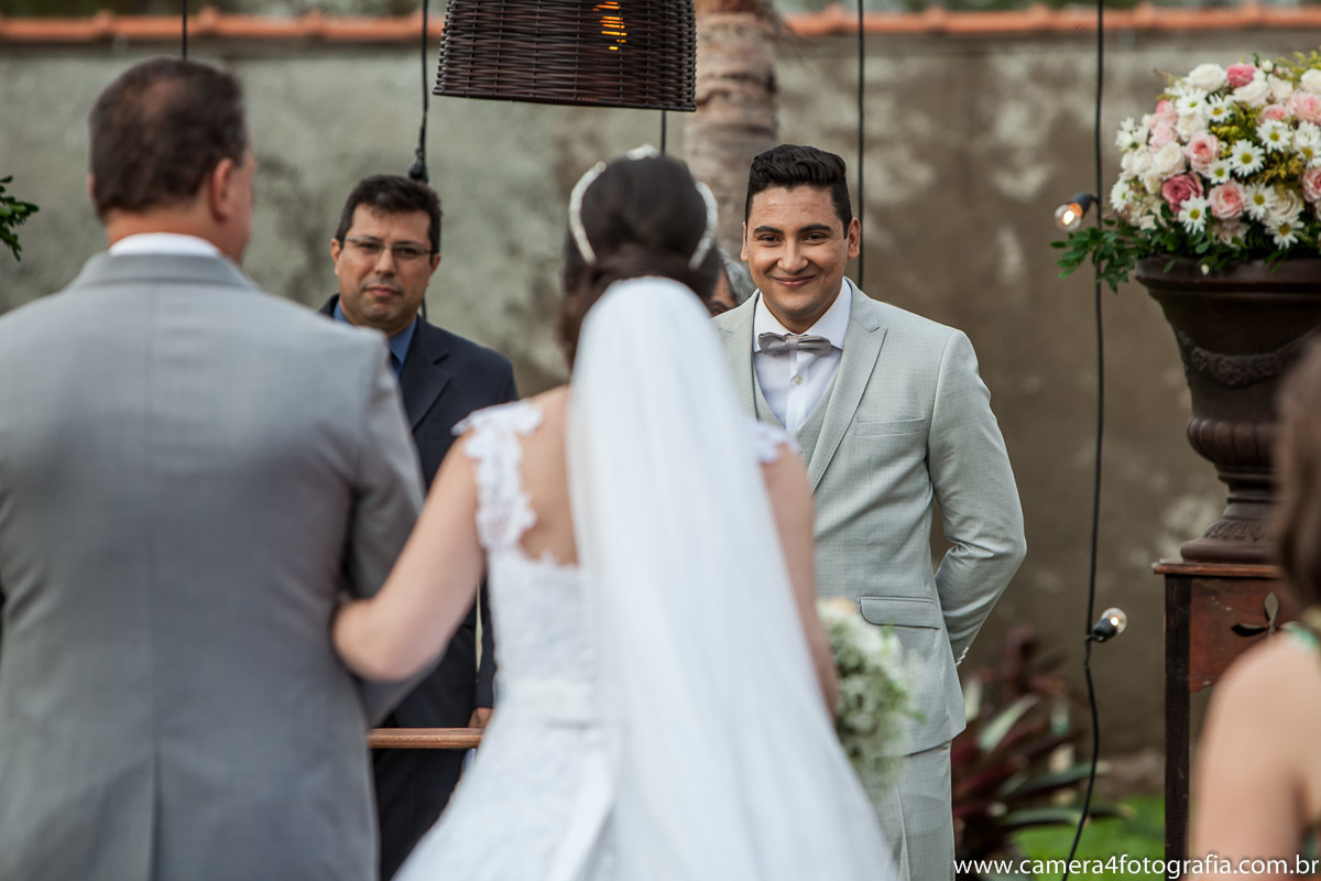 noivo olhando para a noiva entrando na cerimônia do casamento