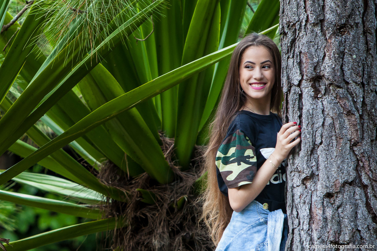 debutante posando para foto ao lada da árvore durante o ensaio pré aniversário de 15 anos