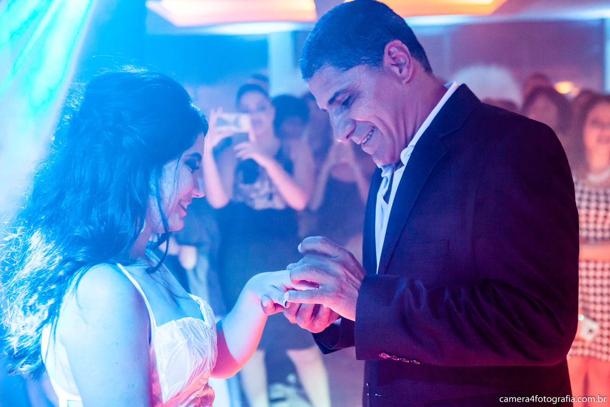 pai colocando o anel na filha de 15 anos durante a festa de aniversário