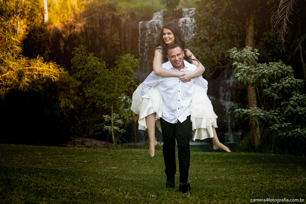 noivo carregando a noiva durante o ensaio pré wedding na cachoeira