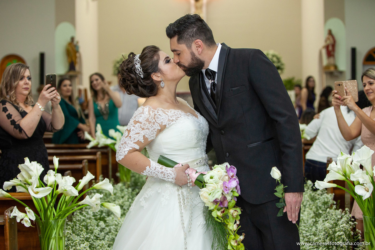 noivo beijando a noiva na cerimônia do casamento