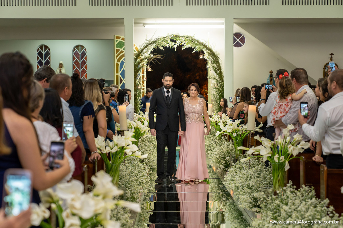 noivo entrando com a mãe na igreja para o casamento