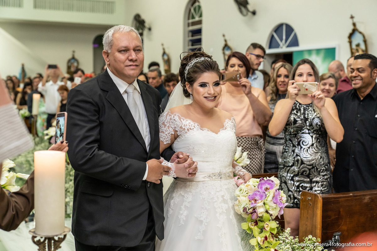 noiva entrando com o pai mãe na igreja para o casamento