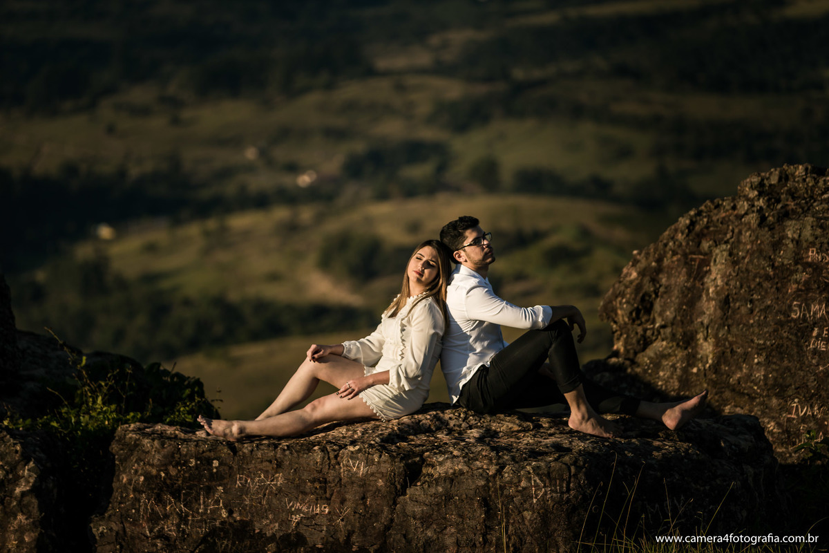 noivos sentados na pedra durante o ensaio pré wedding em pardinho - sp