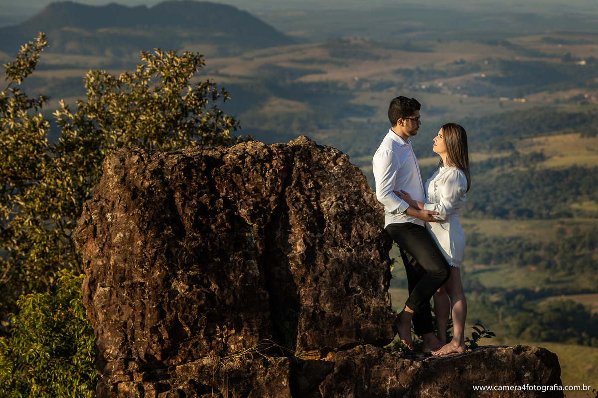casal em cima da pedra durante o ensaio pré wedding em pardinho