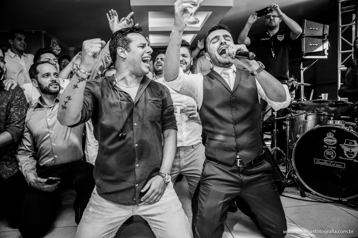 noivo cantando com os padrinhos na festa do casamento