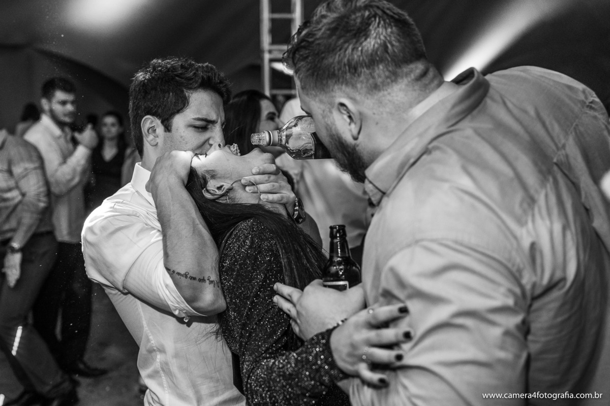 noiva bebendo whisky no gargalo na festa de casamento
