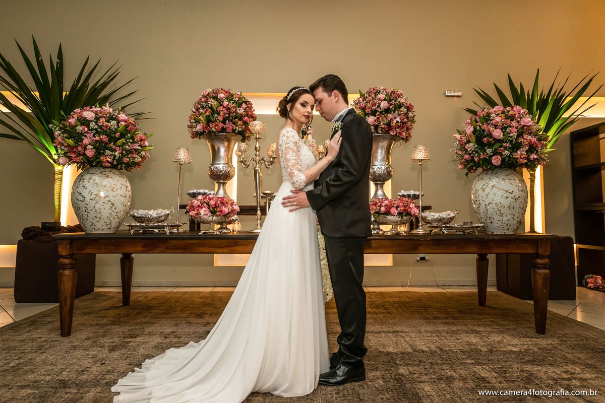 noivos na frente da mesa do bolo no casamento