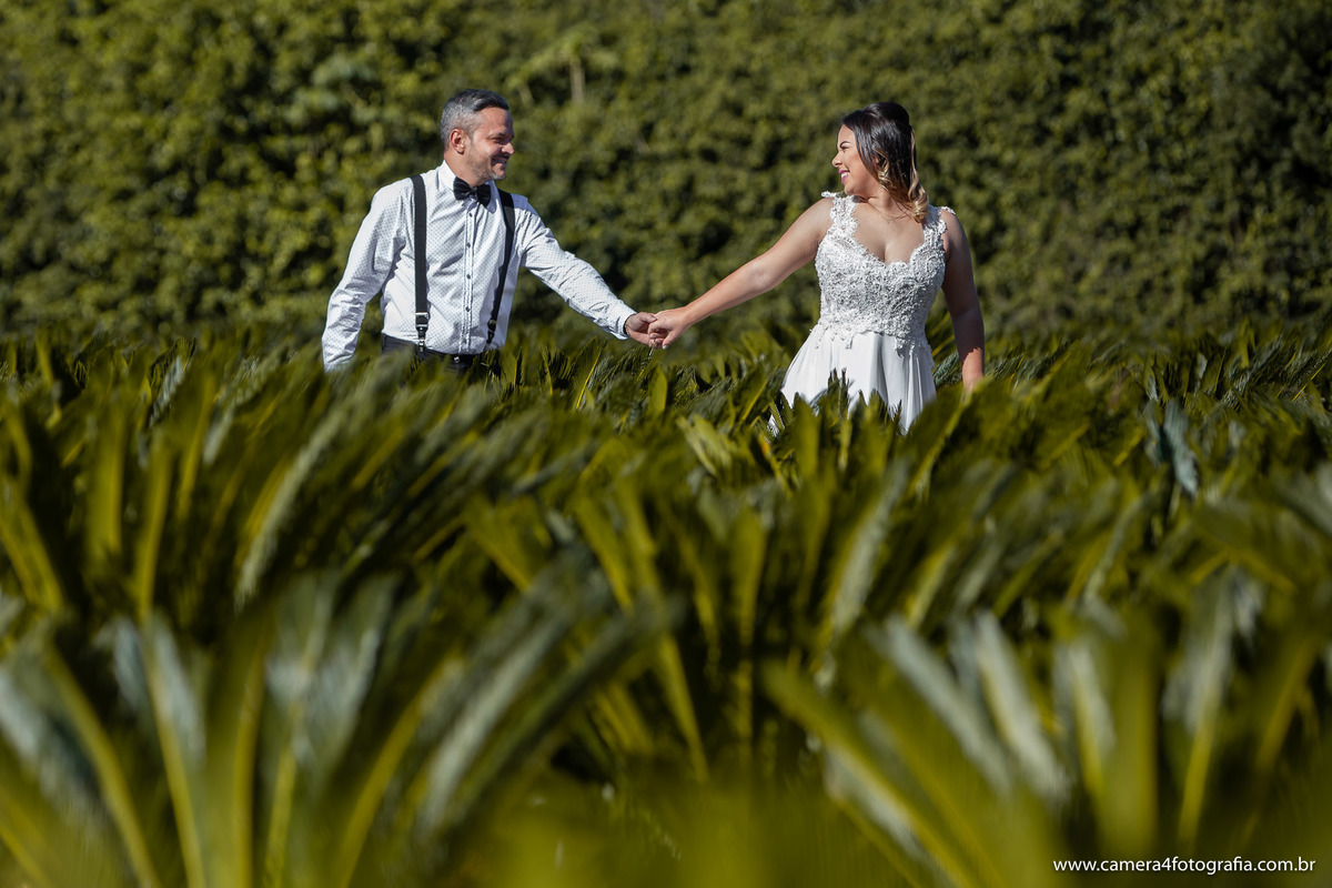 noivos correndo no campo durante o ensaio pré wedding