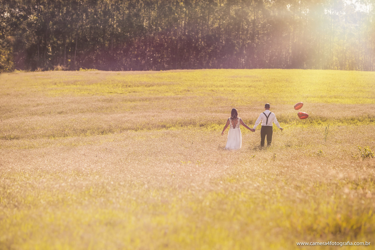 noivos caminhando no campo de feno durante o ensaio pré wedding em Holambra/sp