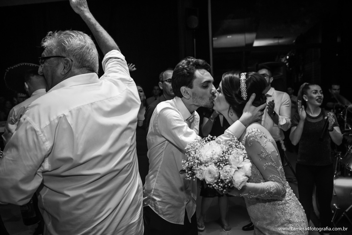 noivos se bejando na festa de casamento