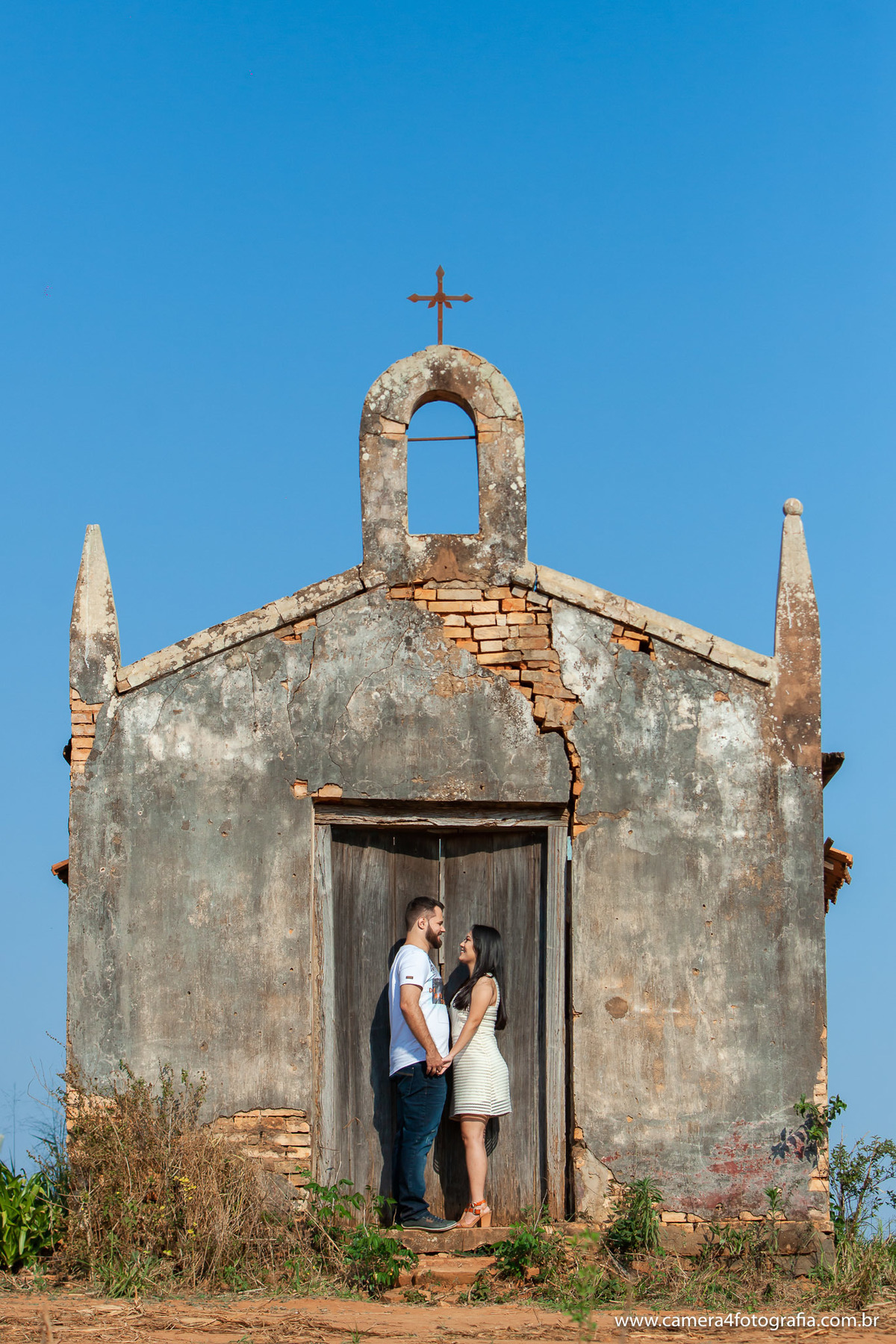 Noivos abraçados na frente da capela durante o ensaio pré wedding