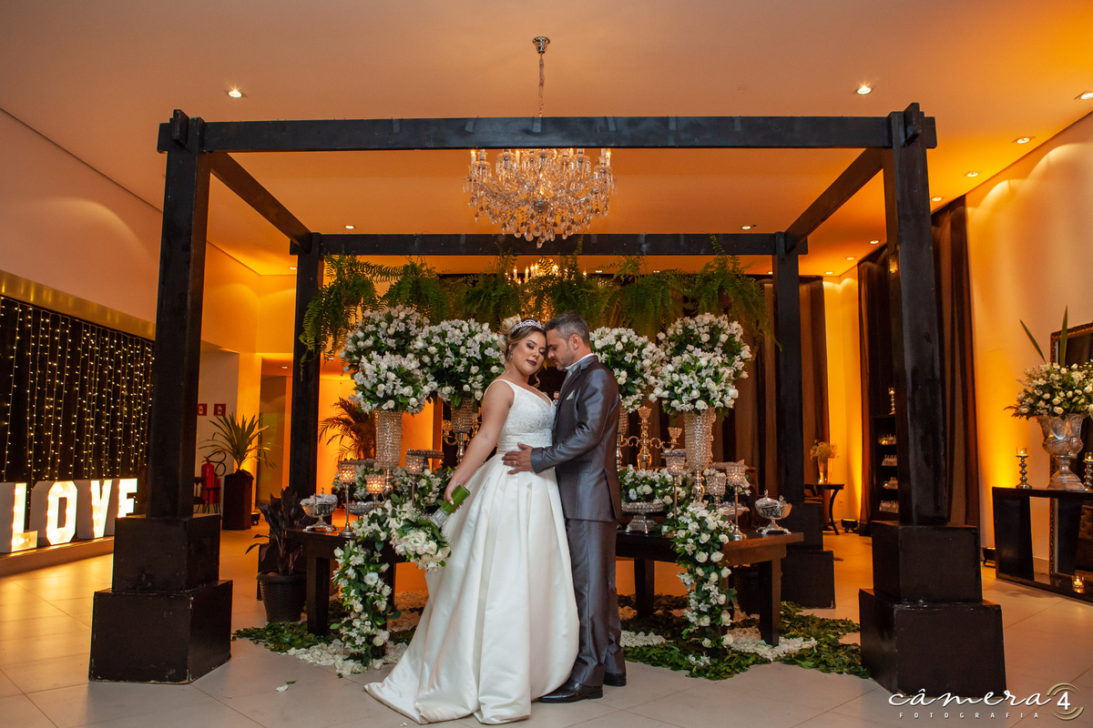 noivos na frente da mesa do bolo no casamento