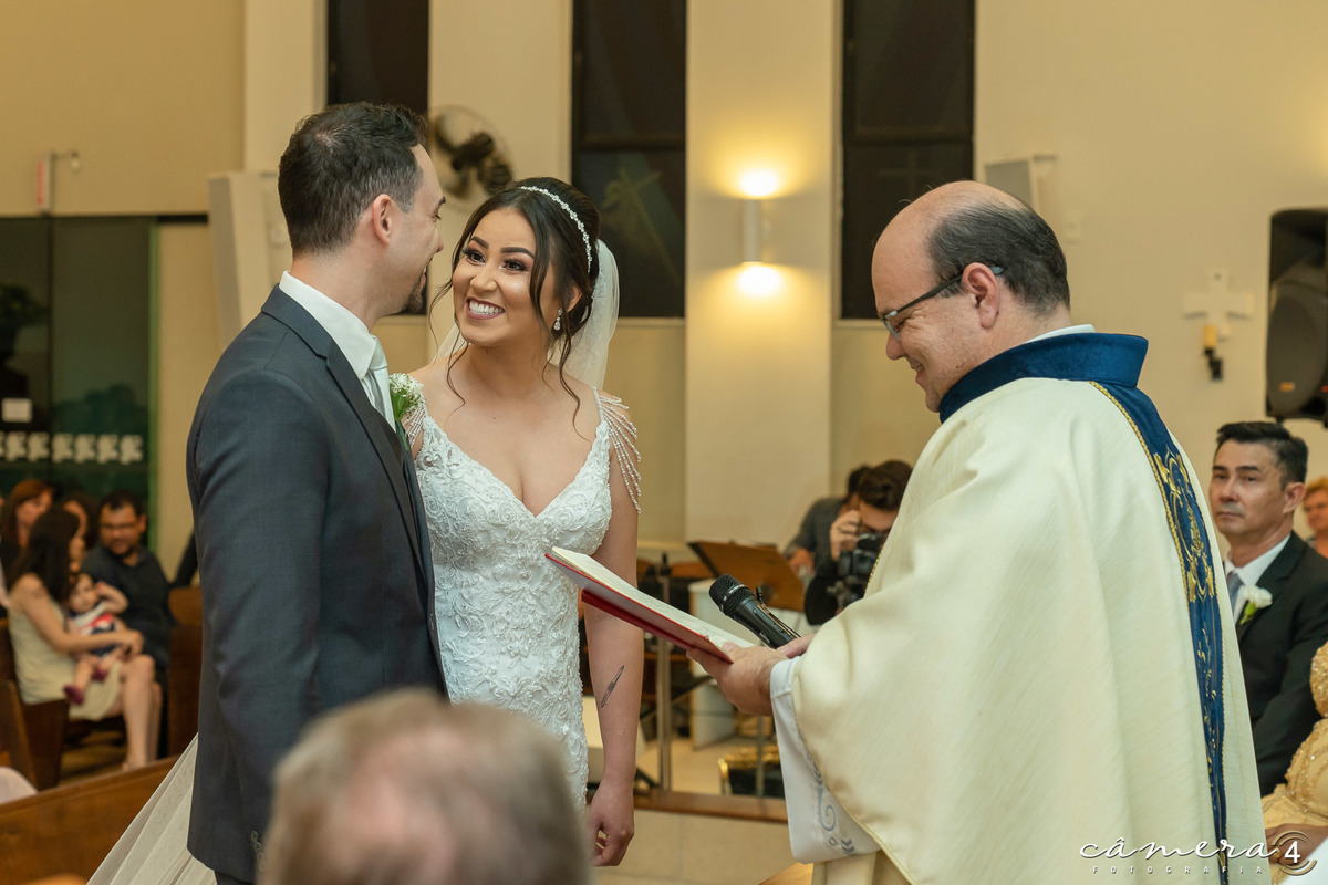 noiva sorrindo para o noivo durante a cerimônia do casamento