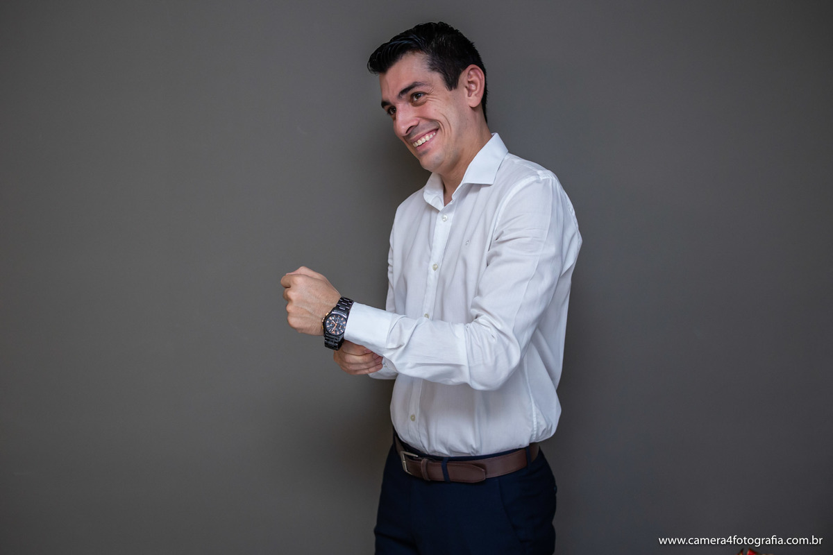 noivo abotoando a camisa no making of