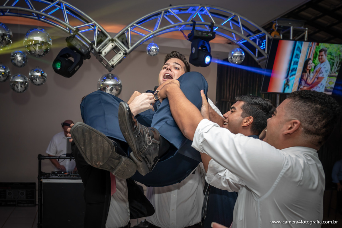 padrinhos jogando o noivo para o alto na festa do casamento