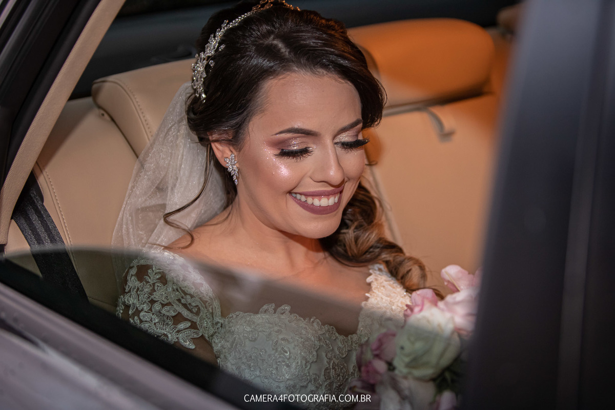 noiva dentro do carro olhando para o buquê no dia do casamento no villa jardim em bauru