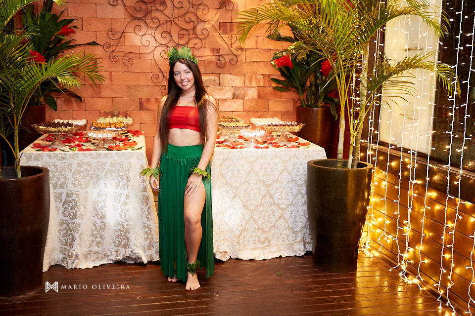 aniversariante sorrindo na frente da mesa de doces