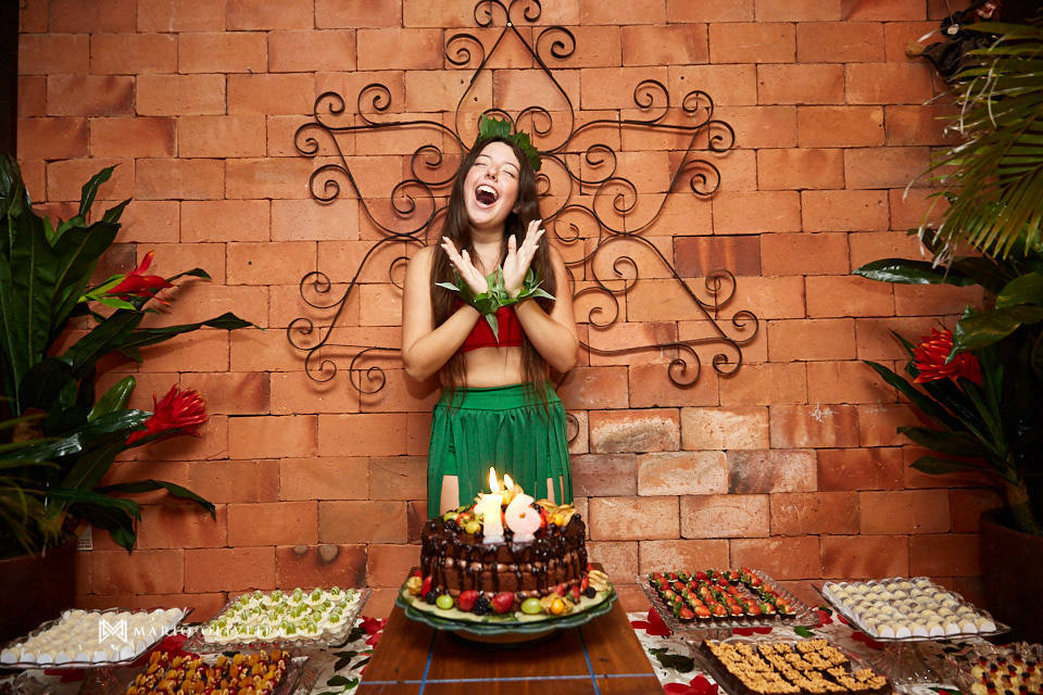 aniversariante cantando parabéns na frente do bolo