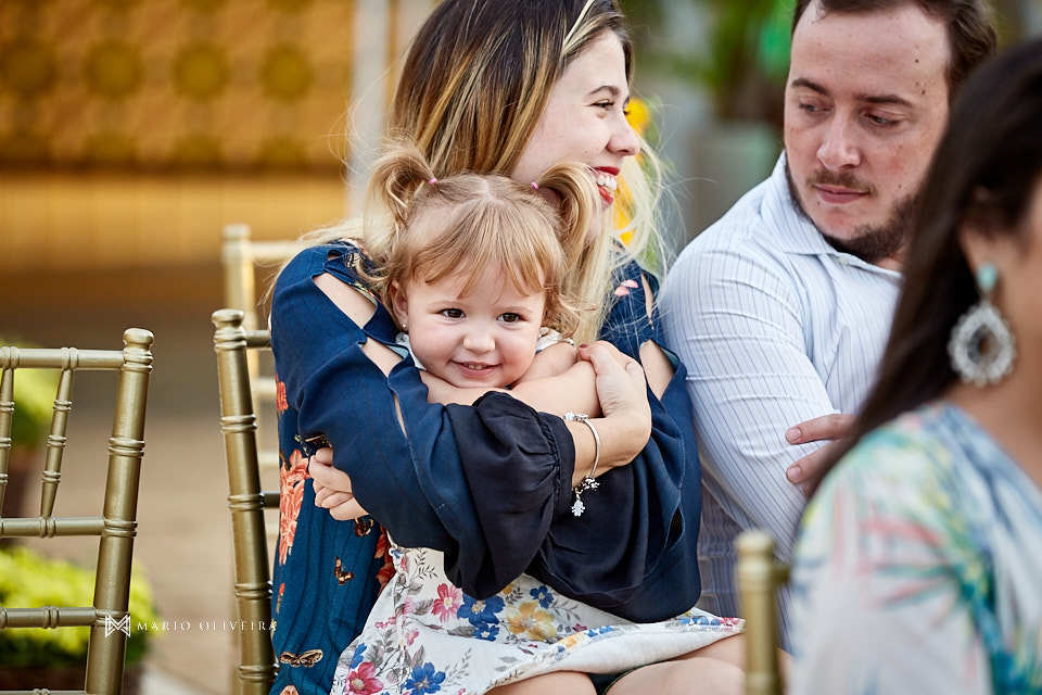 menina sendo abraçada pela mãe e sorirndo