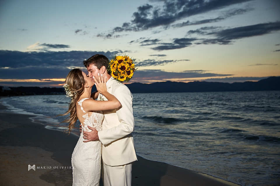 casal de perfil se beijando em frente ao mar