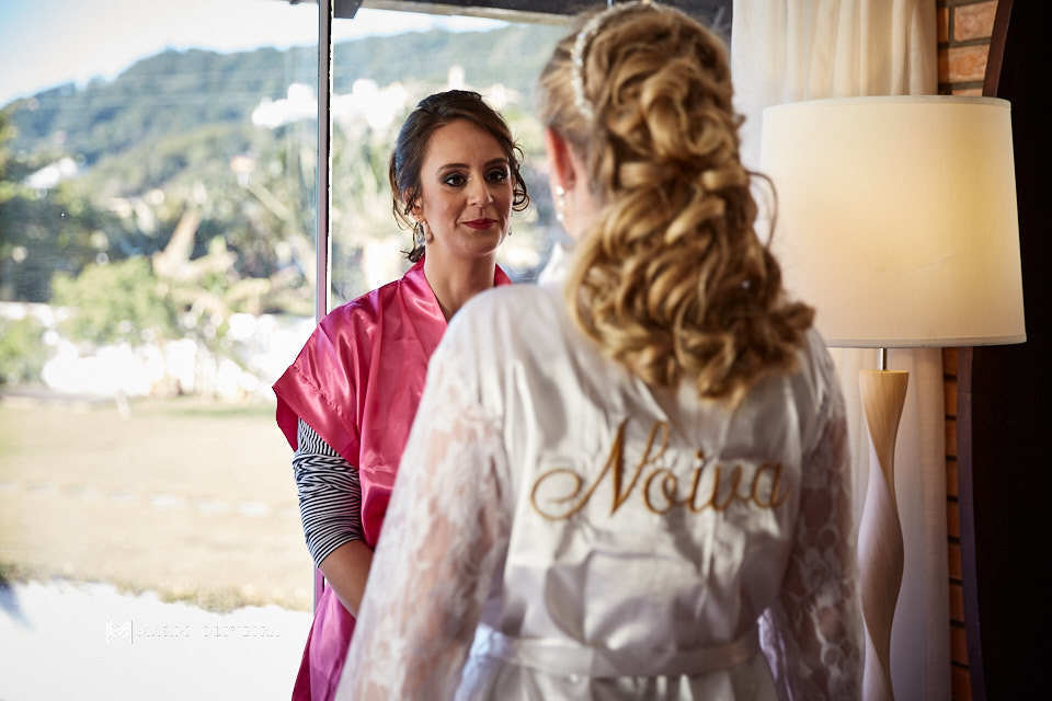 Madrinha conversando com a noiva. Noiva de roupão